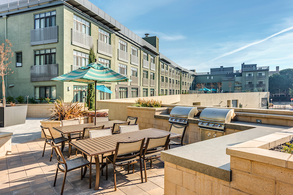 BBQ and picnic area with BBQ's, tables, chairs, and umbrellas.