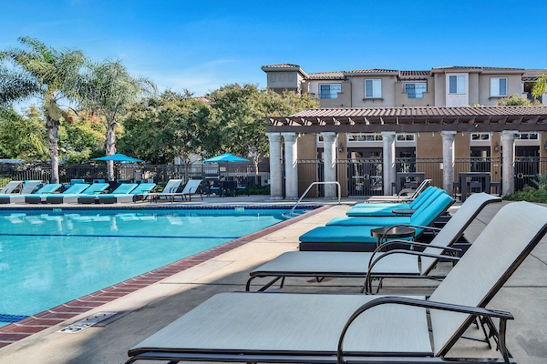 Outdoor swimming pool area with sundeck and lounge seating.