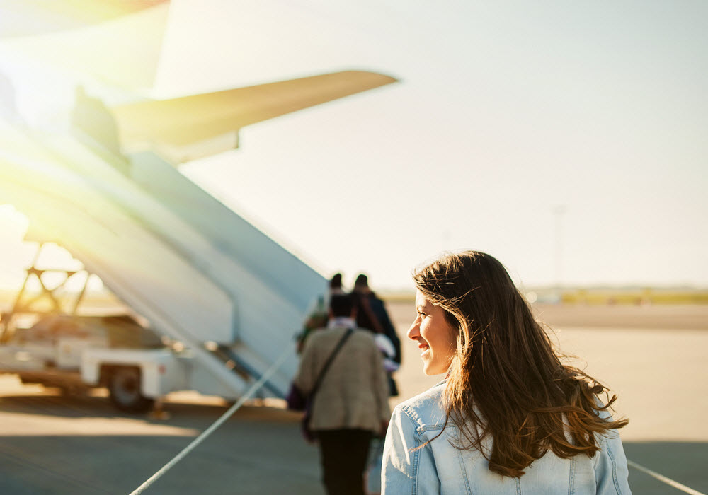 Woman boarding plane at the airport. 