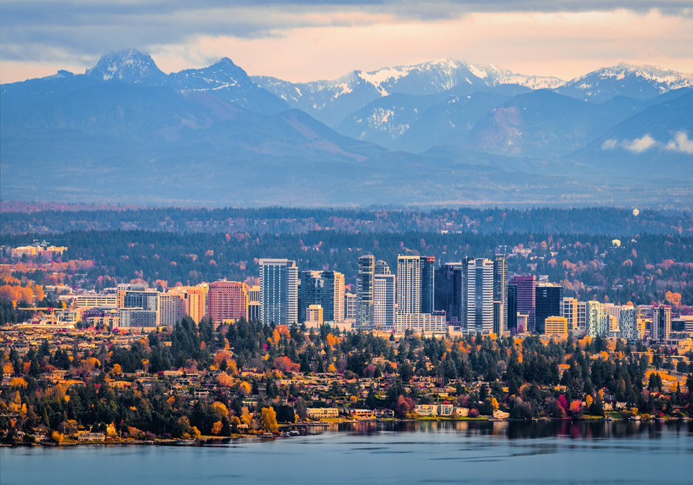 Aerial view of Bellevue, Washington with snowy mountain peaks in the background.