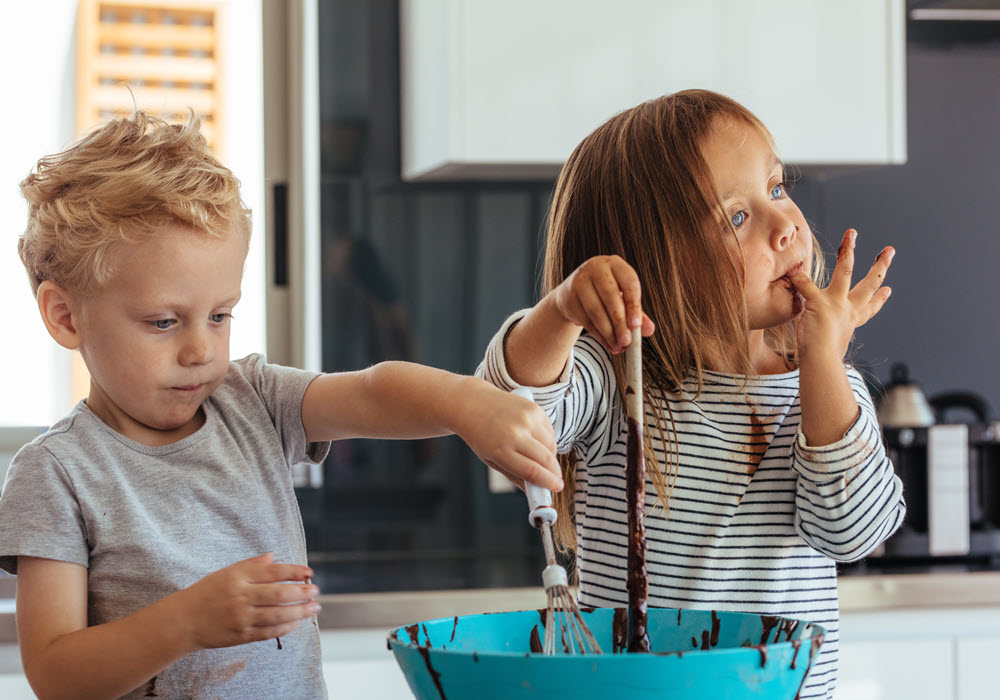 Two kids mixing a bowl of chocolate