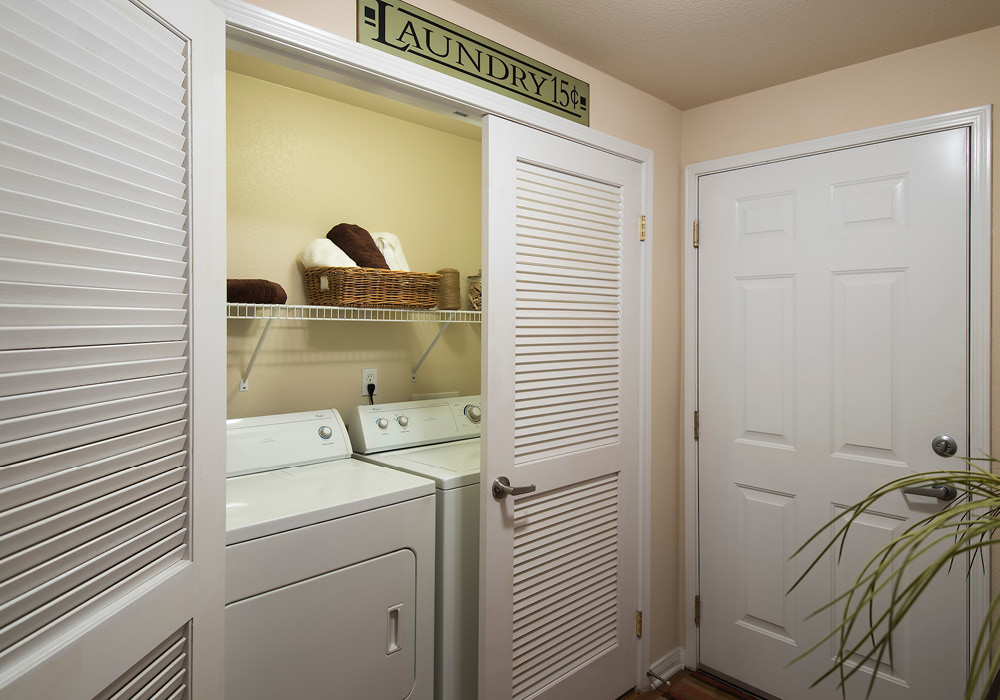 In-unit washer and dryer closet with shelving.
