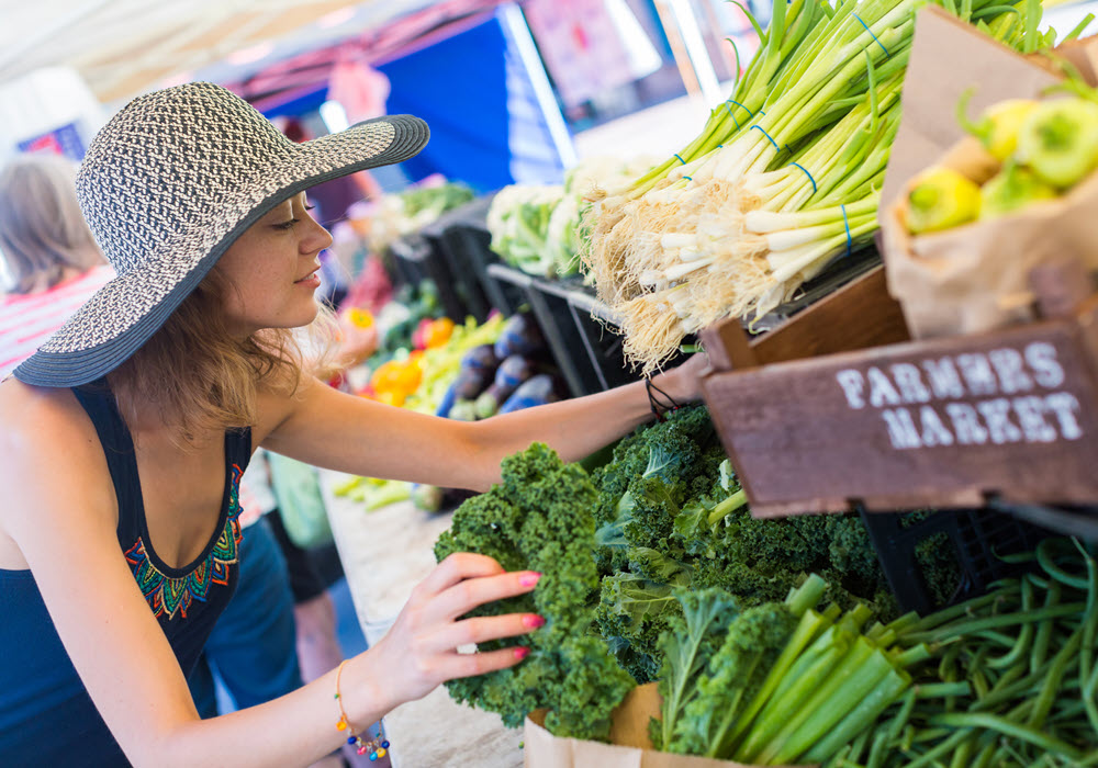 Woman choosing produce at a LA Farmers Market.
