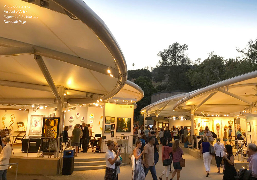 Visitors browsing dimly-lit art at the Festival of the Arts.