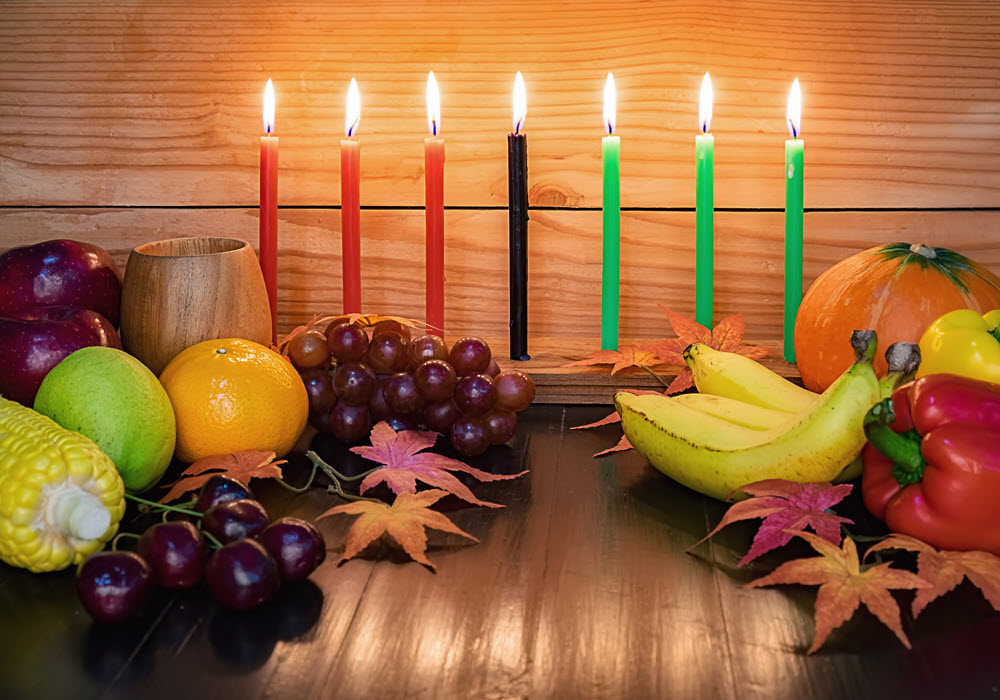 Kwanzaa candles surrounded by fruit and fall decor.