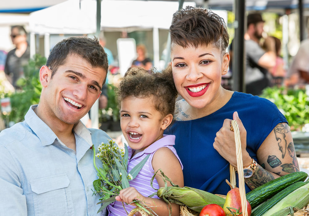 Couple with young child at a local Farmers Market