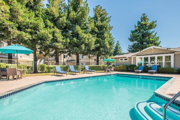 Outdoor swimming pool area with sundeck and lounge seating.