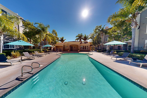 Outdoor swimming pool with lounge furniture.