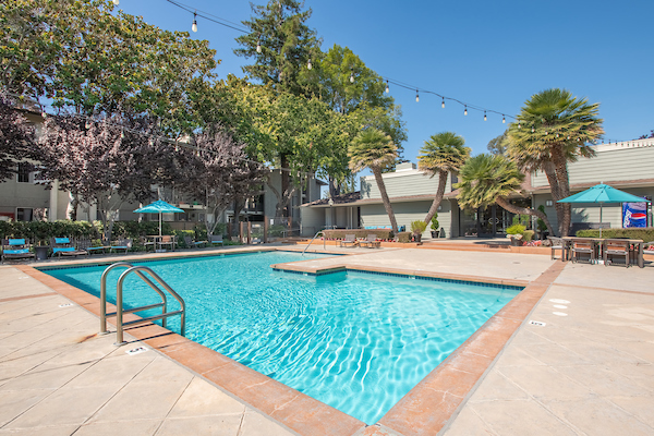 Outdoor swimming pool area with sundeck and lounge seating.