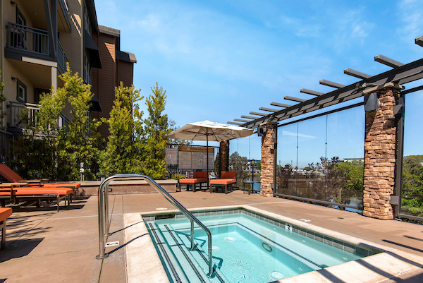 Spa on deck overlooking water with lounge seating.