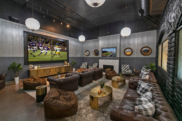 Media room with hardwood style vinyl flooring, fireplace, and sofas.