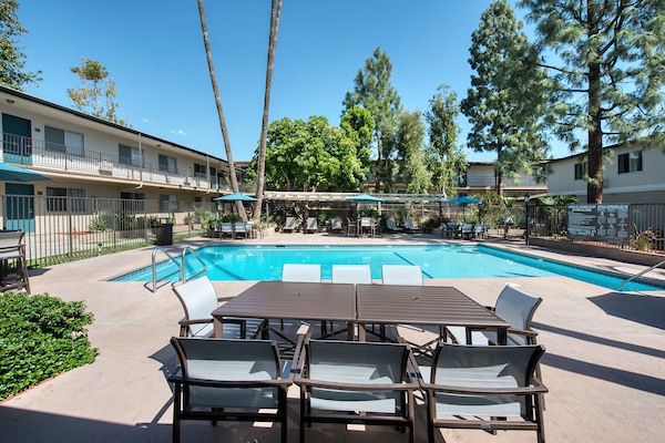 Outdoor swimming pool area with table and chairs.